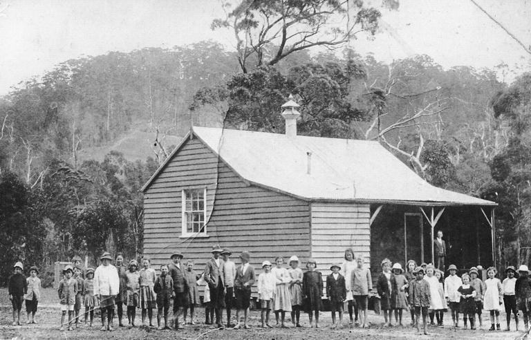 One roo timber school with children in front